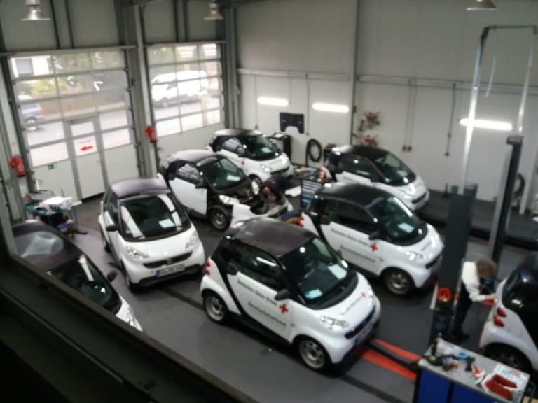 Flotte von Smart-Fahrzeugen in der Werkstatthalle